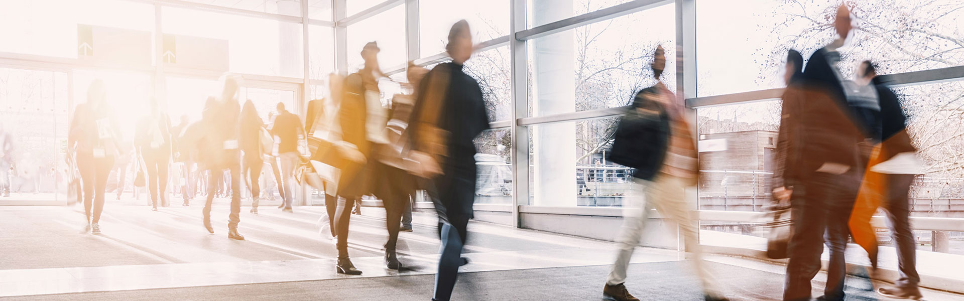 Inside the Hamburg conference center, people briskly walking to the conference. 